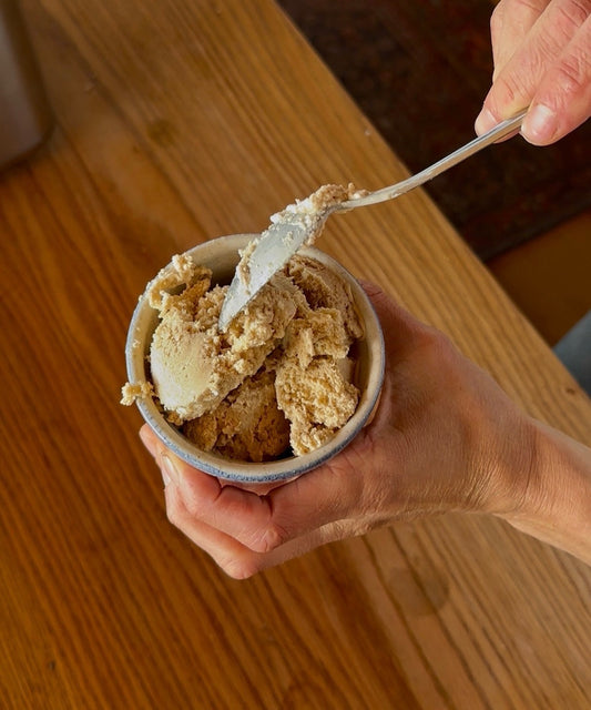 Ice cream being scooped by spoon.